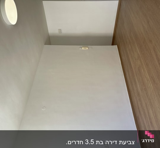 קיר צבוע בלבן עם מנורה עגולה